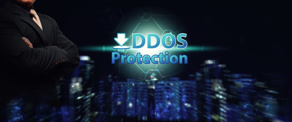 DDOS Protection over the city night scene for network security protect : Business man and DDOS icon with light of secure 
